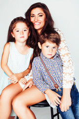 young mother with two children on white background, happy smiling family inside, lifestyle real people concept