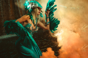 Fantasy scene, Beautiful blonde woman in fancy dress and blue angel wings on arms