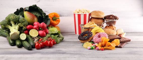 Wall Mural - healthy or unhealthy food. Concept photo of healthy and unhealthy food. Fruits and vegetables vs donuts and fast food