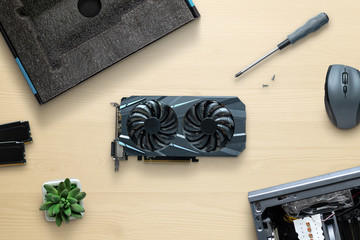 Fototapete - Graphic card installation concept. Work desk with modern GPU, screwdriver, case, memory, mouse. Gaming PC build concept.