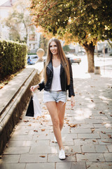 Wall Mural - A girl walking with bags after successful shopping on Black Friday