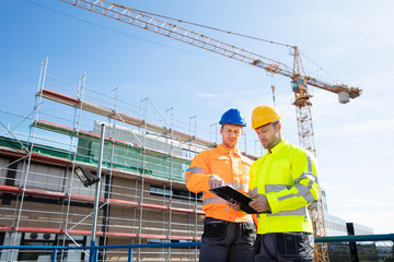 Wall Mural - Two Male Engineers Supervising The Construction Site