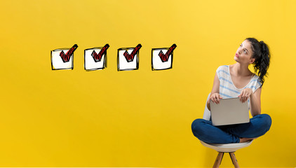 Wall Mural - Checklist with young woman using a laptop computer