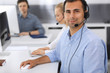 © Iryna - Call center. Group of casual dressed operators at work. Focus on adult businessman in headset at customer service office. Telesales in business