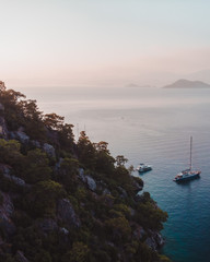 Wall Mural - Evening sunset on the mediterranean sea. Luxury yachts lined up along the Turkish coastline, islands can be seen in the distant background. Beautiful scene shot aerially from a drone.