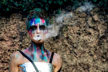 A young woman with abstract colorful make-up in a fantasy look style