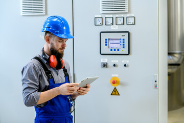 Wall Mural - worker with helmet ,ear protector and tablet computer