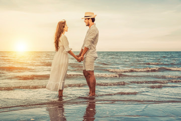 romantic couple in love holding hands in the beach