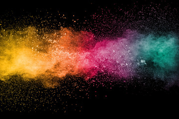 Colorful background of pastel powder explosion.Rainbow color dust splash on black background.