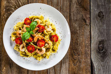 Wall Mural - Shrimps with pasta tagliatelle with spinach and tomatoes