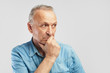 © amixstudio - Portrait of a stylish modern elderly man on a white background in the studio. Senior boss thinking in a pensive pose