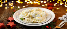 Christmas Dumplings Stuffed With Mushroom And Cabbage On A White Plate On A Rustic Wooden Table. Traditional Christmas Eve Dish In Poland