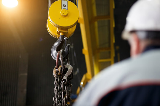 yellow overhead-traveling crane with hard hat worker operator