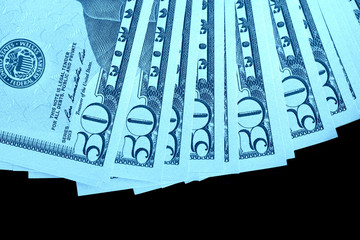 Fifty dollars banknotes isolated on black background close-up. Blue color toning