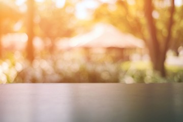 Wall Mural - wooden table with nature bokeh in the morning, suitable for background, backdrop, and mock up.
