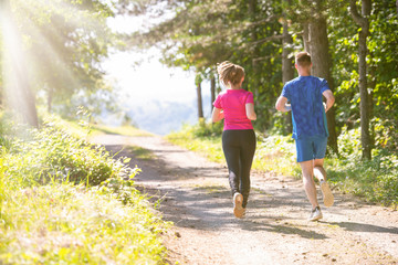 young couple jogging on sunny day at nature