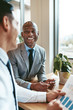 © Flamingo Images - African American businessman laughing with a colleague in an off