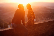 Smiling Man And Woman Hugging And Kissing At Sunset