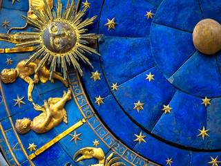 Gemini astrological sign on ancient clock. Detail of Zodiac wheel with Sun and Twins. Golden symbol of Gemini on star circle closeup. Concept of astrology and horoscope.