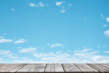 Vintage wooden table top with nature view burred white cloundy on blu sky background