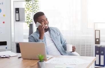 Poster - Handsome businessman talking on phone and drinking coffee in office