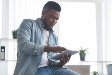 Poster - Portrait of concerned black employee using digital tablet in office