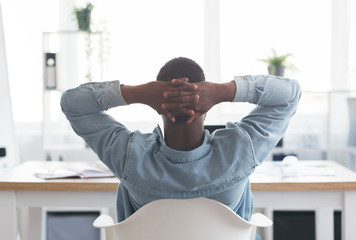 Poster - African american worker resting at workplace, leaning back on chair