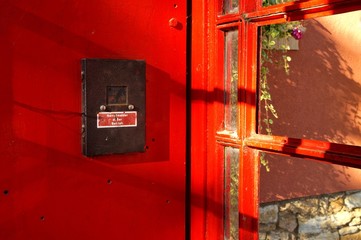 close up of Classic English London Phone Booth. The german word Notrufmelder ausser Betrieb is written inside of the red phone box