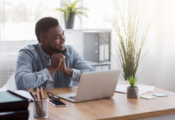 Poster - Pensive black businessman dreaming about something while working in office