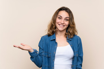 Wall Mural - Young blonde woman over isolated background holding copyspace imaginary on the palm