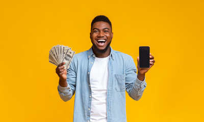 Poster - Cheerful black blogger holding smartphone and bunch of dollar banknotes