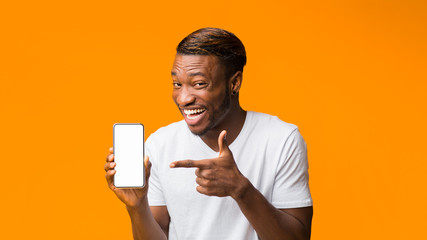 Wall Mural - Black Man Showing Phone Blank Screen Standing, Orange Background, Mockup