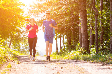 young couple jogging on sunny day at nature