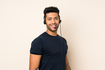 Wall Mural - Young handsome man over isolated background working with headset