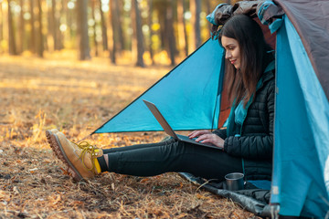 young girl using laptop in camping tent