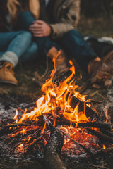 traveler couple camping in the forest and relaxing near campfire after a hard day. concept of trekki
