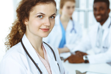 Happy doctor woman with medical staff at the hospital. Multi ethnic people group