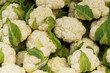 White cauliflower with green leaves in a crate on the market.