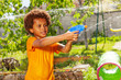 Boy playing water gun fight game with his friends