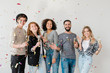© pressmaster - Joyful young friends of various ethnicities having fun against white wall