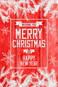 Merry Christmas card with evergreen on wood background
