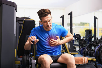 Young man having heart attack in gym