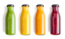 Green, Yellow, Orange And Red Smoothie In Glass Bottles