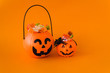trick or treat for halloween. Pumpkin bucket with sweets and spiders on an orange background. Sweets for kids for Halloween. Copyspace
