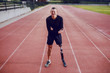 © Dusan Petkovic - Sporty man with artificial leg standing on running track and having pain in stomach.