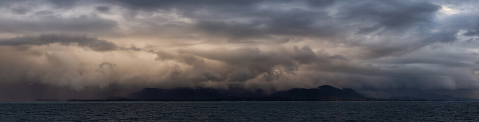 Wall Mural - Dramatic Panoramic View of a cloudscape during a dark, rainy and colorful sunset. Taken on the Ocean Coast of Alaska, USA.
