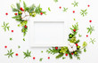 Christmas composition  with photo frame, cotton flower, branches of spruce and holly with red berries on white background. Merry christmas greeting card with empty space for holiday text.
