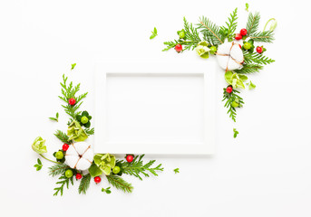 Wall Mural - christmas composition with photo frame, cotton flower, branches of spruce and holly with red berries