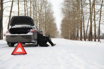 Man and car. Winter walk and car repair.