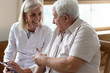 © fizkes - Elderly man patient and middle-aged nurse talking indoors